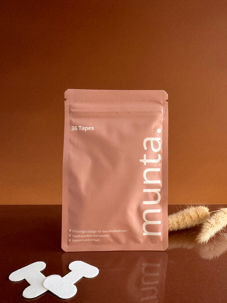 Freisteller Munta Verpakung auf braunem Hintergrund mit zwei einzelnen Muntapes davor liegend.