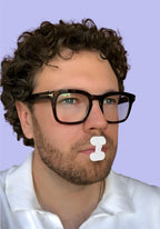 Mann mit Brille trägt Munta Mundpflaster. Mouth Taping auch mit Bart anwendbar.