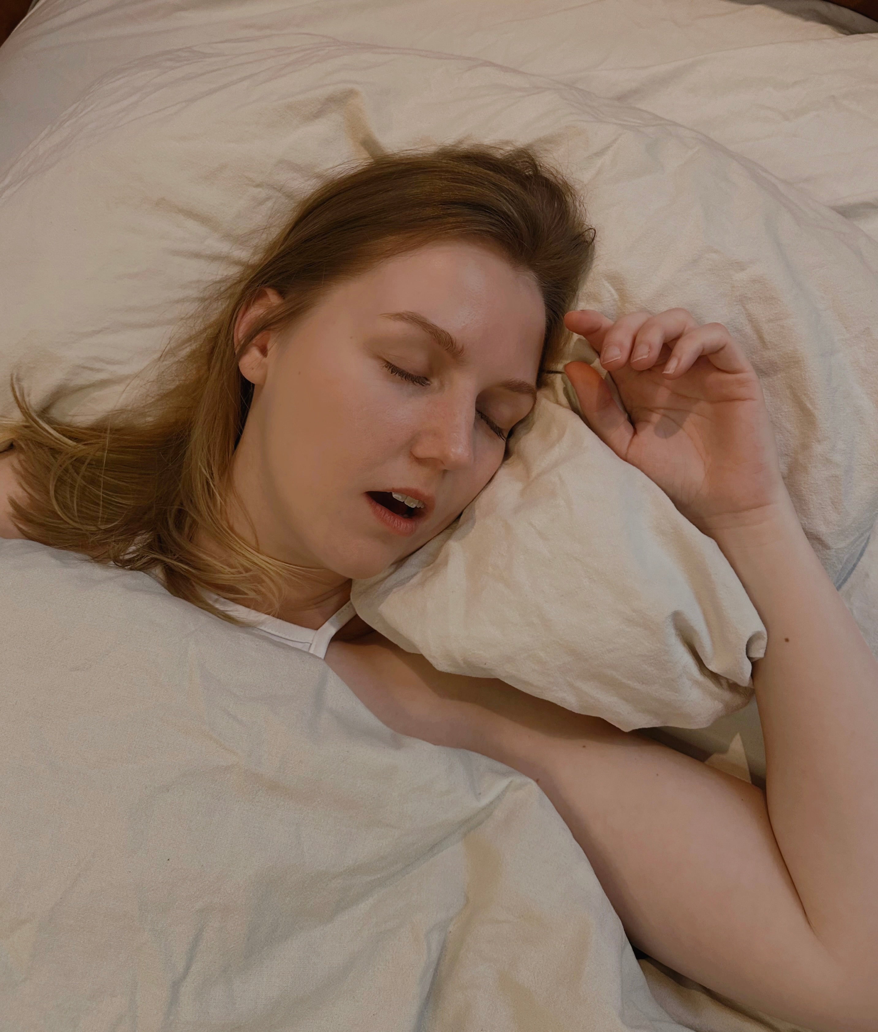 Frau schäft im Bett mit offenem Mund - Mundatmung